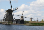 Rij molens aan het water in Kinderdijk - Poster